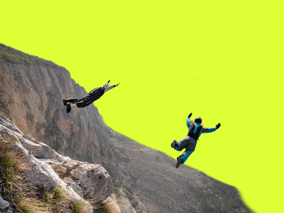 Against a neon green background, two people jump off a cliff wearing parachute packs