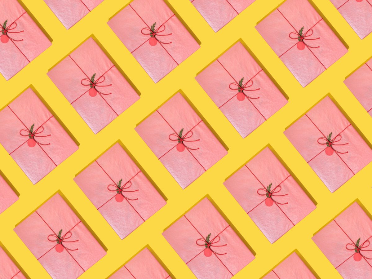 A graphic image of books wrapped in pink holiday paper, lined up against a yellow background. Each book is tied with red string and has a red decorative ball in the center.
