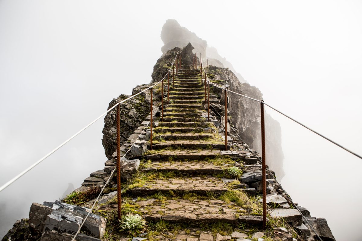 Stairs set into a mountain trail, leading into the mist