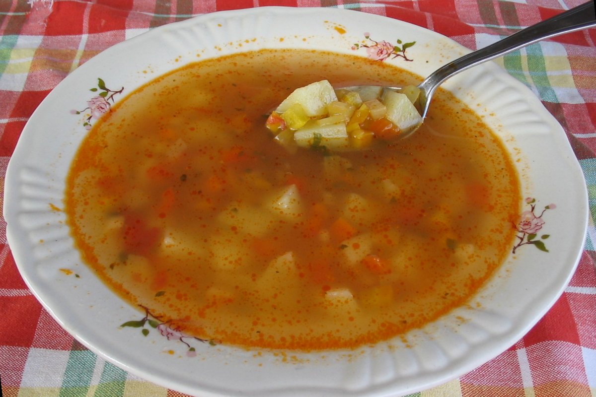 a bowl of vegetable soup with a spoon in it