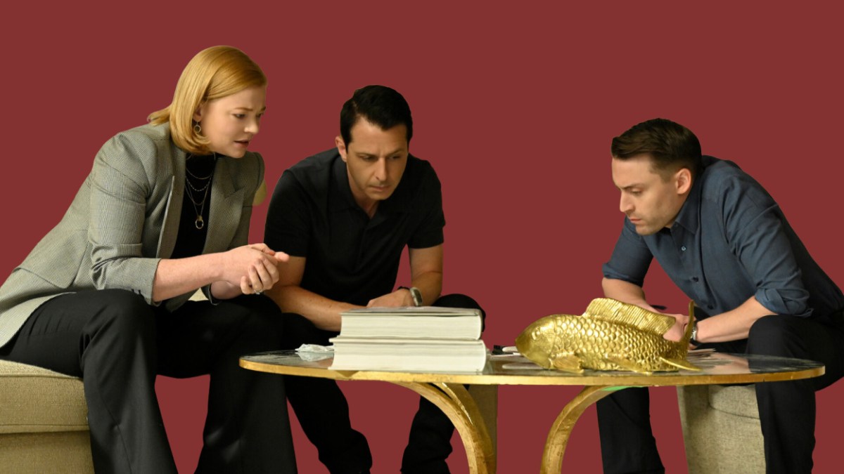 Three characters from the HBO show "Succession" — Shiv, Kendall, and Roman Roy — sit around a table with serious looks on their faces.